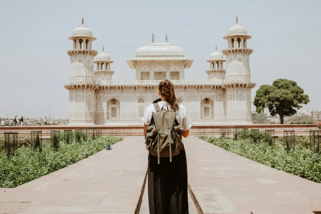Tourist standing on the central pathway facing Itimad-ud-Daulah's Tomb (Baby Taj) in Agra, Uttar Pradesh, India.