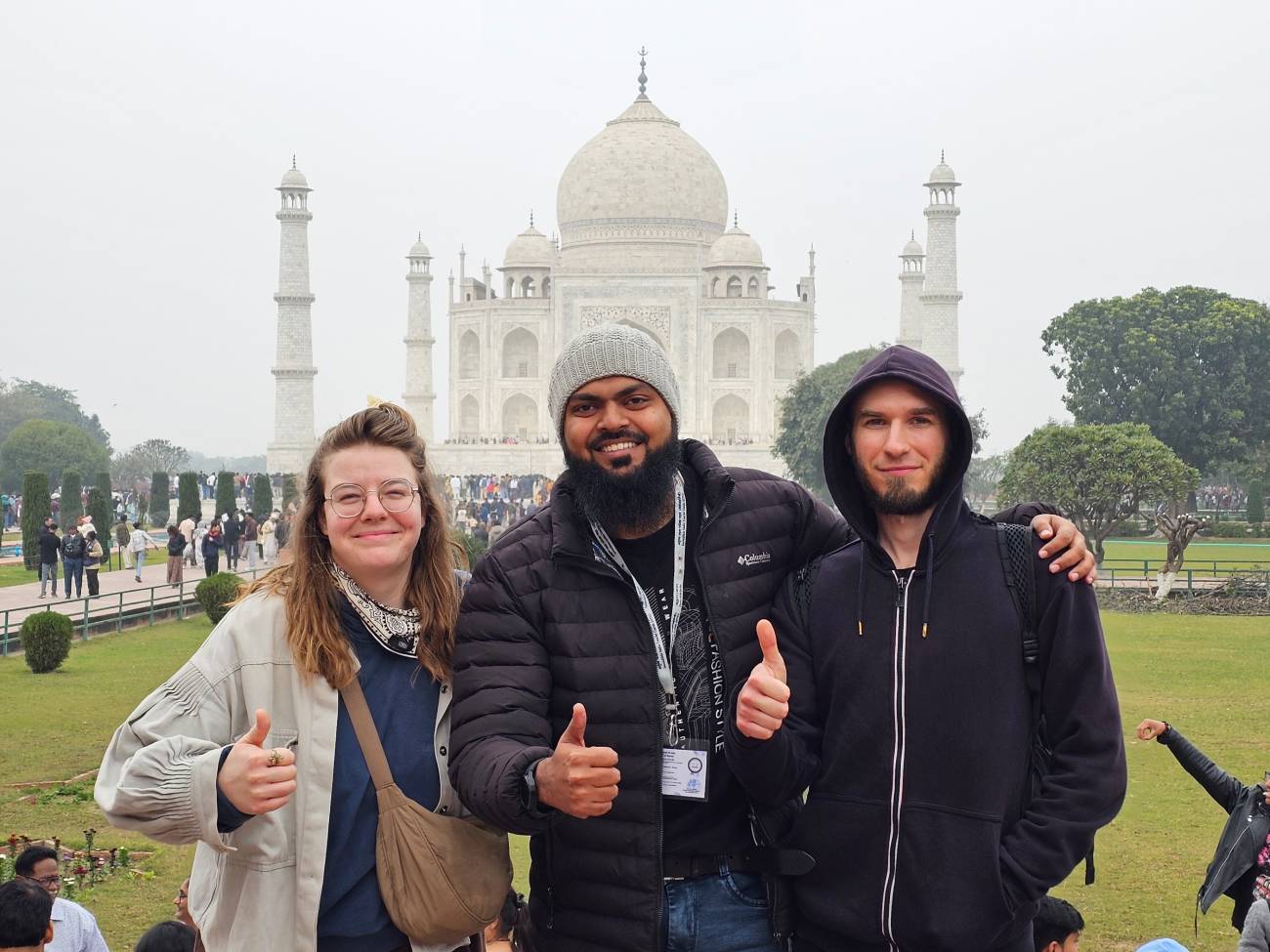 Explore North India’s Most Iconic Wonders 91 Kamran Khan, a tour guide from Agra Trip Packages, standing with two international travelers in front of the Taj Mahal in Agra, India.