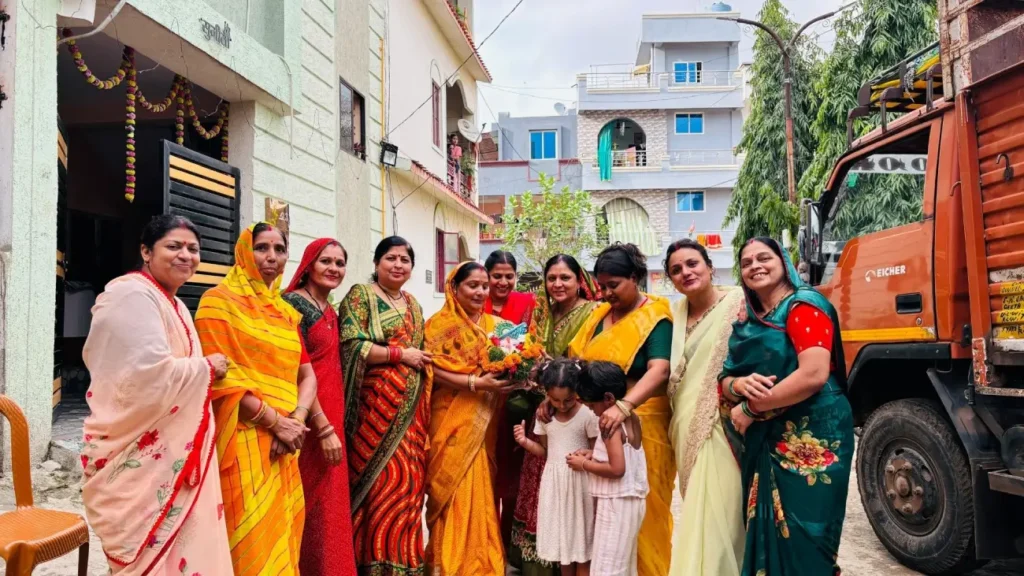 Women dressed in colorful traditional sarees gather in a residential neighborhood during an Indian cultural celebration, showcasing community bonding, festive traditions, and vibrant ethnic attire.