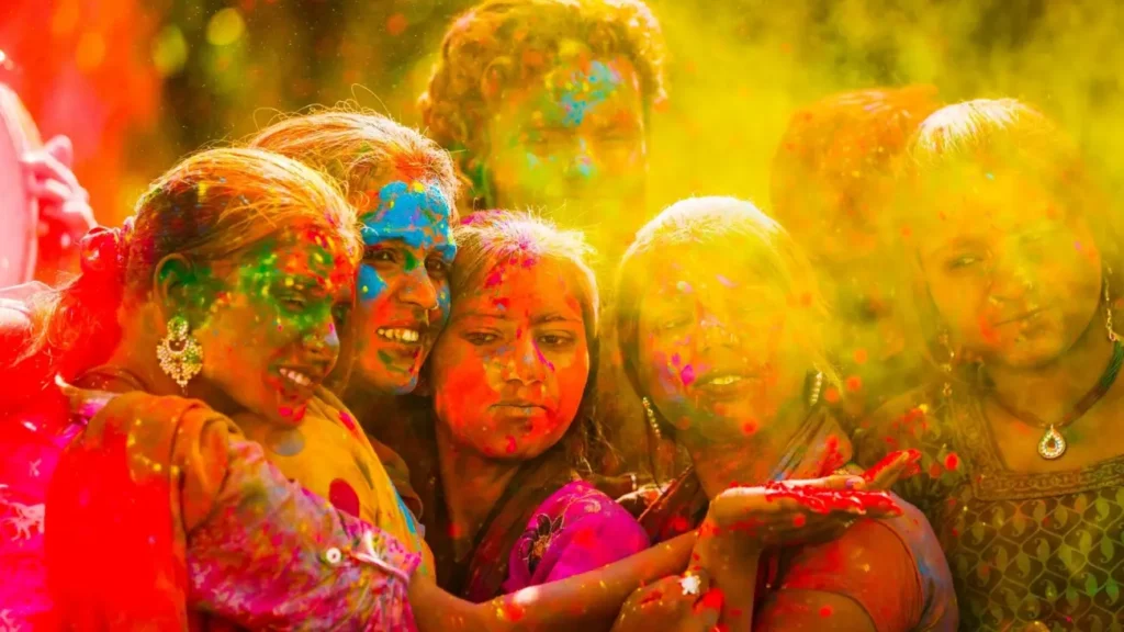 People celebrating Holi by throwing vibrant colored powders, showcasing India's Festival of Colors, joyful traditions, and cultural heritage.