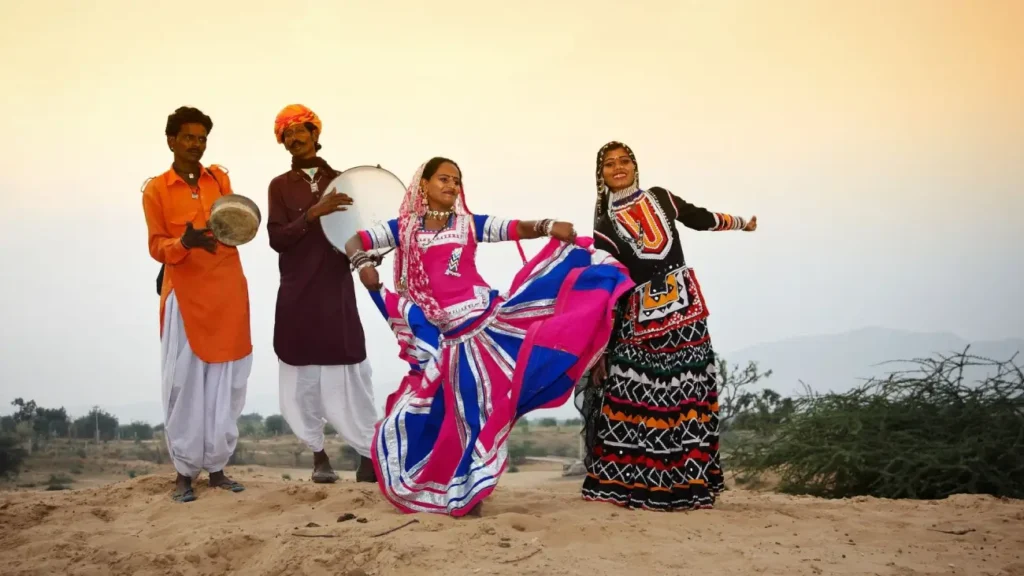 Indian folk dancers performing in colorful traditional attire with musicians playing drums, showcasing the vibrant music and dance traditions of India's cultural heritage.
