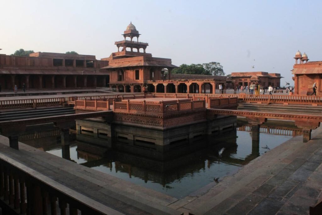 Anup Talao reflecting pool surrounded by red sandstone Mughal buildings and courtyards at Fatehpur Sikri, Uttar Pradesh, India.