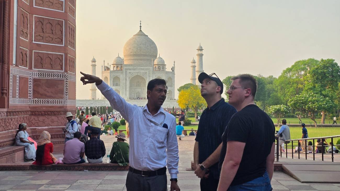 Professional tour guide Anjum Saeed explaining the Taj Mahal to international tourists during a private sightseeing tour in Agra, India.
