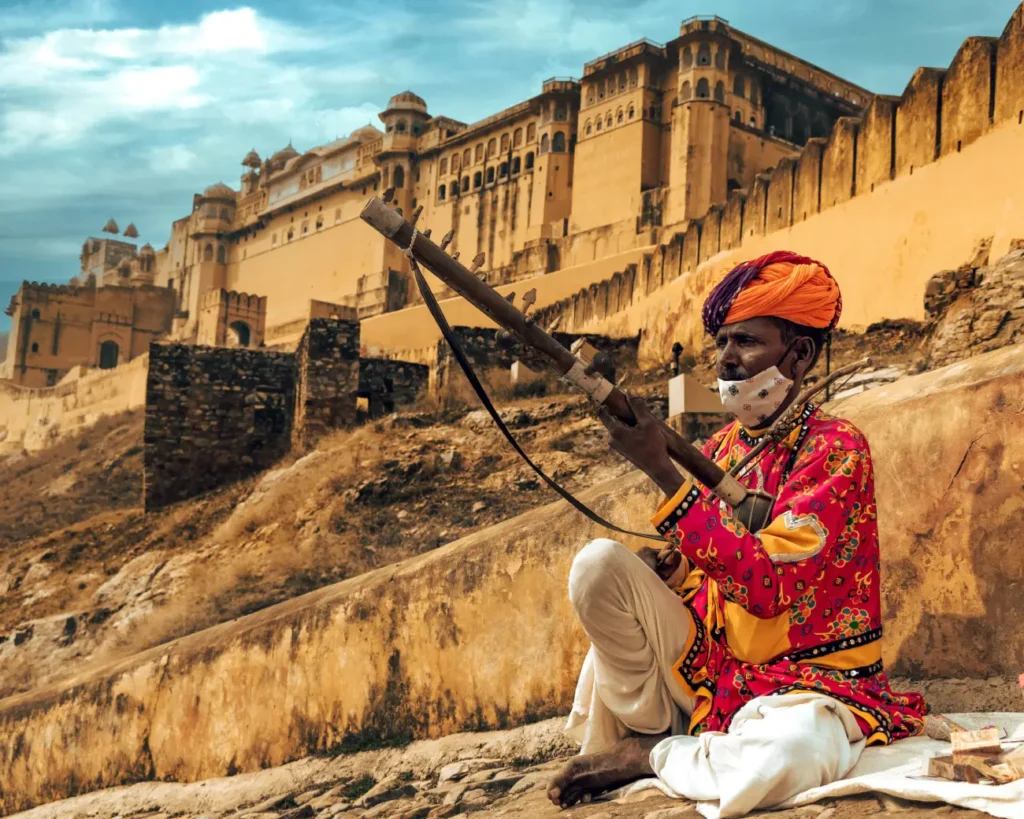 Traditional Rajasthani folk musician playing a string instrument near Amer Fort in Jaipur, Rajasthan, India.